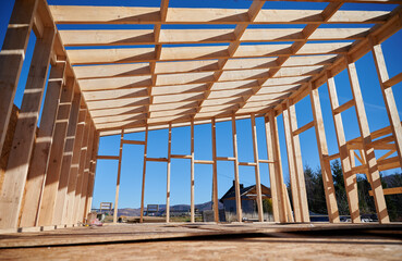 Bottom view of wooden frame house in the Scandinavian style barnhouse under construction on blue sky background.