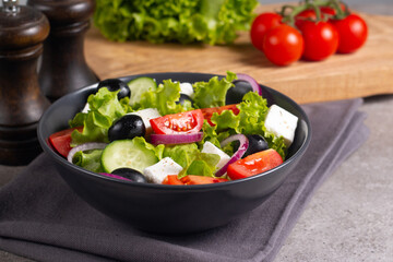 Fresh Greek salad with delicious rucola, spinach, arugula, feta cheese, cucumber, red onion and cherry tomato Healthy and diet food concept.