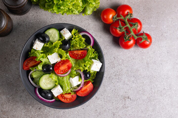 Fresh Greek salad with delicious rucola, spinach, arugula, feta cheese, cucumber, red onion and cherry tomato Healthy and diet food concept.