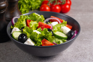 Fresh Greek salad with delicious rucola, spinach, arugula, feta cheese, cucumber, red onion and cherry tomato Healthy and diet food concept.