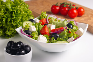 Fresh Greek salad with delicious rucola, spinach, arugula, feta cheese, cucumber, red onion and cherry tomato Healthy and diet food concept.