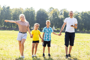 Happy family enjoying life together at meadow outdoor.