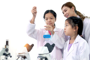 Students and teacher in lab coat have fun together while learn science experiment in laboratory. Young adorable Asian scientist kid adding some chemical to blue flask with pipette, little children stu