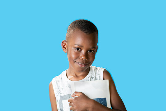 giovane ragazzo felice di tenere un libro in mano con lo sfondo blu
