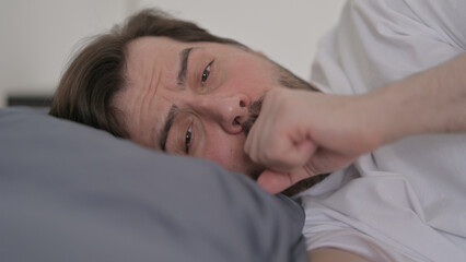 Portrait of Young Man Coughing while Sleeping in Bed