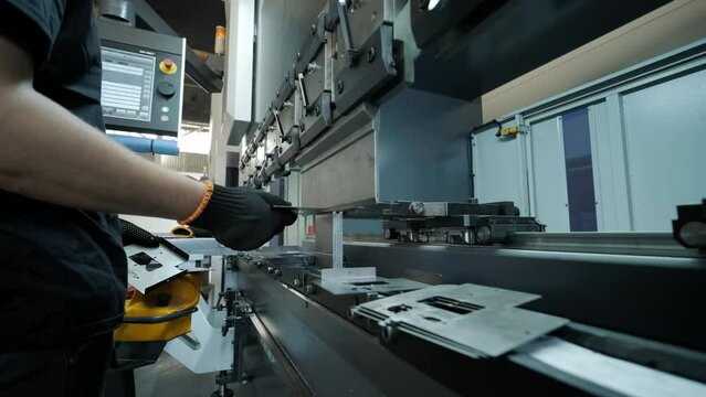 Operator working cut and bending metal sheet by high precision metal sheet bending machine, cnc control metal sheet bending machine in factory