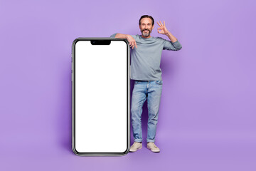 Full size photo of handsome male showing okay sign recommending product placard isolated on purple...