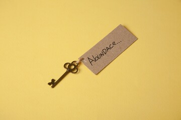 Key of abundance on a yellow background. A concept of happy abundant life.