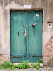 Old green wooden door in the middle of Venice, Italy