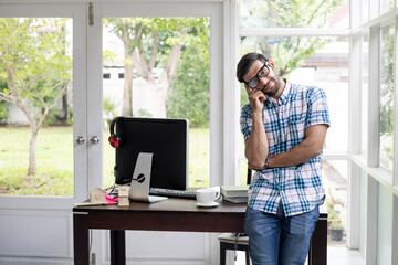 Young man working from home by computer.