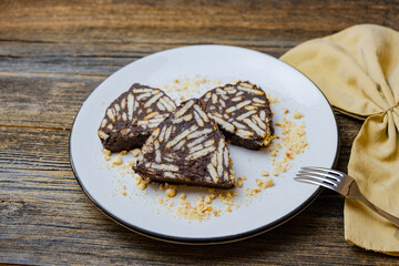 Mosaic cake with homemade chocolate and biscuits on a white plate, Turkish name is “Mozaik Pasta”