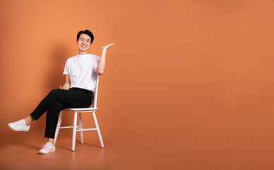 man sitting on chair  isolated on orange background