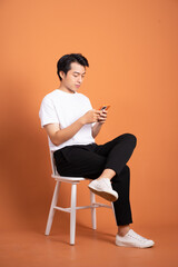 man sitting on chair  isolated on orange background