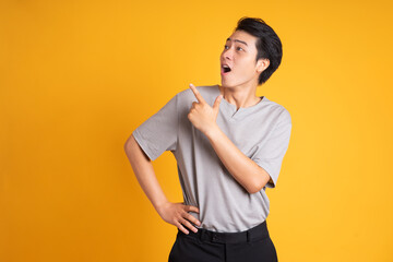 Asian young man posing on a yellow background