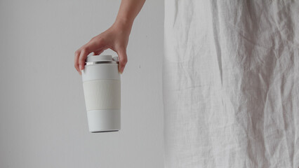 Hand woman holding reusable a drink water cup or coffee cup,  Zero waste, Environmental friendly,...