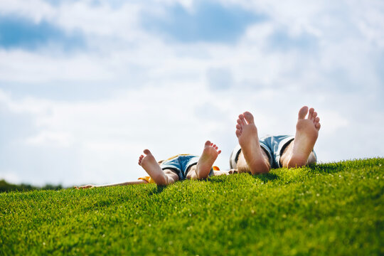 Happy Family in Summer time. Child with Father Together. Feet Barefoot on the green grass. Healthy Lifestyle. Dad and Son