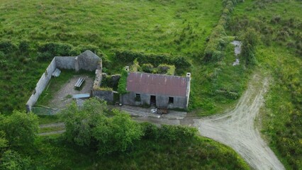 Aerial view of old abandoned stone farmhouse in the Irish countryside