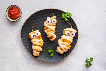 Stuffed jalapeno peppers look like a mummies for Halloween party food