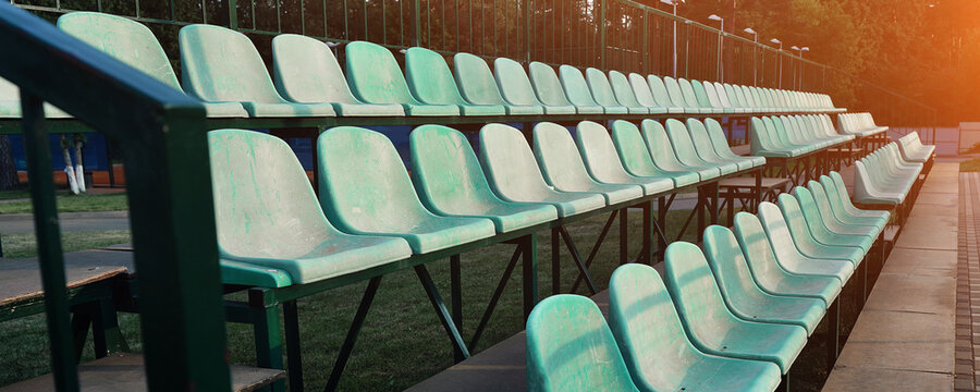 Empty green colored plastic seat rows on stadium tribune. Sport and recreation and leisure concept.