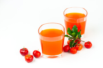 Acerola or barbados cherry juice in glass with fresh acerola cherry fruits isolated on white background.