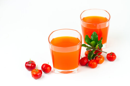 Acerola or barbados cherry juice in glass with fresh acerola cherry fruits isolated on white background.