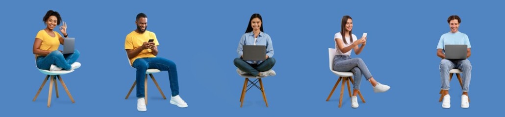 Cheerful young diverse women and men sit on chairs with laptop and smartphone