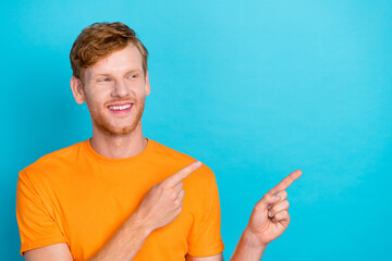Photo of cheerful handsome positive guy red hairstyle wear yellow t-shirt indicating empty space...
