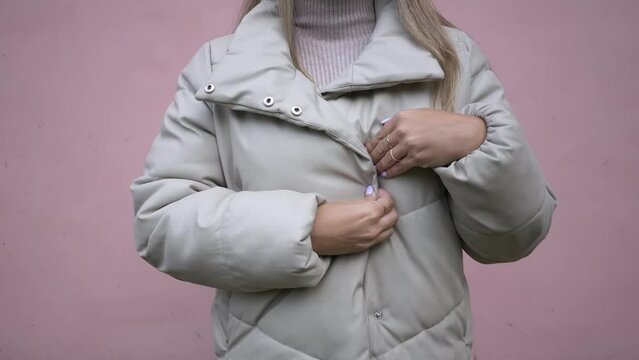 The girl zips up her jacket, posing directly for the camera. Warm autumn clothes.