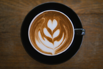 Hot coffee Latte art on wooden table top view.