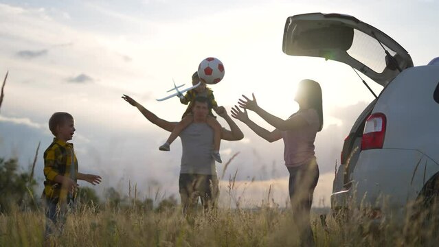 Happy family concept. Silhouette of family in car. People travel by car. Picnic in nature. Family game by the car. Happy road trip weekend. Sunset in nature. Picnic by car. Summer travel in nature