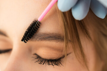 Eyebrows of girl after plucking and haircut close-up. The makeup artist will do permanent eyebrow makeup. Makeup and cosmetology concept