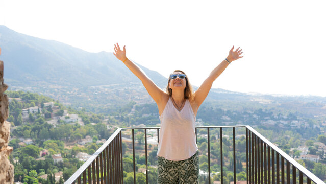 Woman with open arms looking to the horizon in concept of freedom.