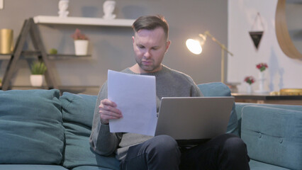 Casual Man with Laptop having Failure on Documents, Sofa