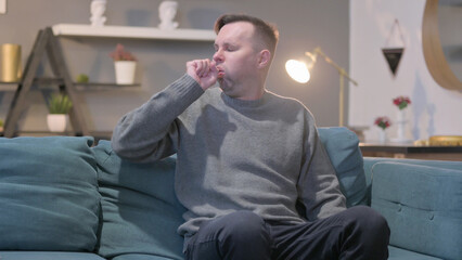 Casual Man Coughing while Sitting on Sofa