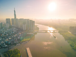 Fototapeta premium Aerial view of Ho Chi Minh City skyline and skyscrapers on Saigon river, center of heart business at downtown. Morning view. Far away is Landmark 81 skyscraper