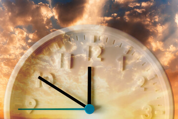 Golden cloudy sunset sky and close up of clock. Double exposure. Daylight Savings Time Concept
