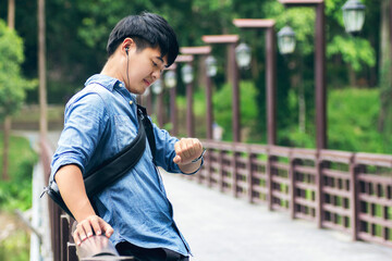 Asian man listening music and chill out on the bridge