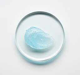 Brushes of  blue gel on round glass forms on a light background.