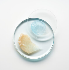 Brushes of cream and blue gel on round glass forms on a light background.