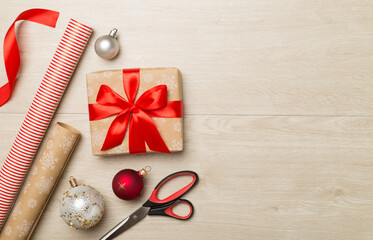 Gift boxes, paper's rools and decorations on wooden background, top view