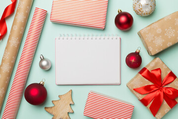 Gift boxes, paper's rools and decorations on color background, top view
