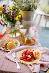 Breakfast on beautifully decorated table with flowers in garden