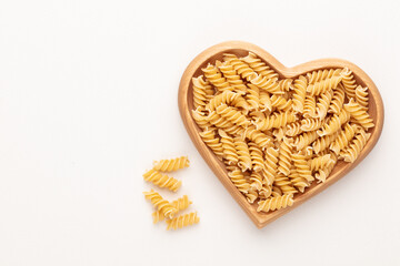 Pasta in a heart shaped wood bowl.
