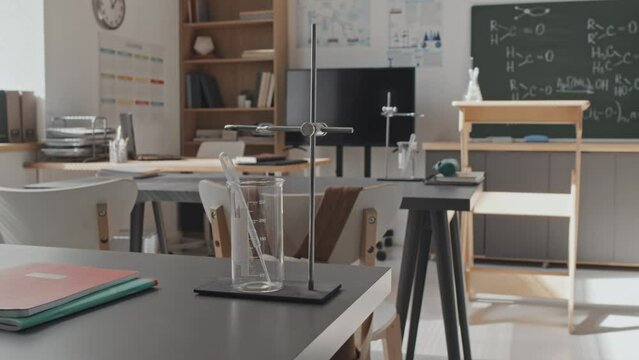 Selective focus of beaker on school desk in classroom at daytime