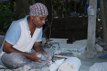 Breathing life into stone, stone artisans or stone masons are the stone carvers of Odisha who are constantly working to create masterpieces out of black granite stone. - obrazy, fototapety, plakaty