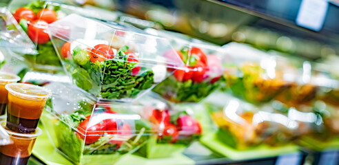 Vegetable salads displayed in a commercial refriger