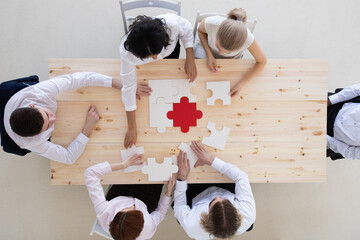 Diverse business people assembling puzzle