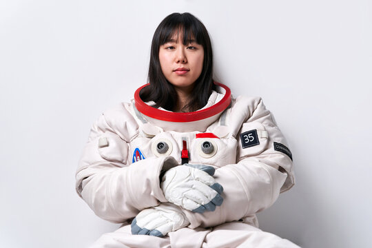Asian cosmonaut looking at camera in studio