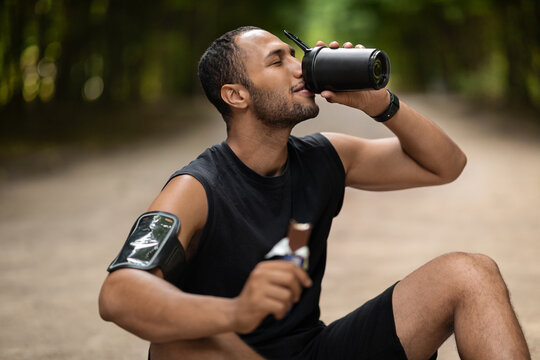 Tired middle eastern sportsman having snack while training outdoors