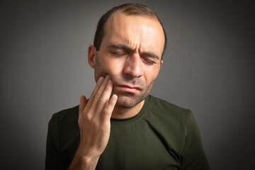 Caucasian man suffering from tooth pain.